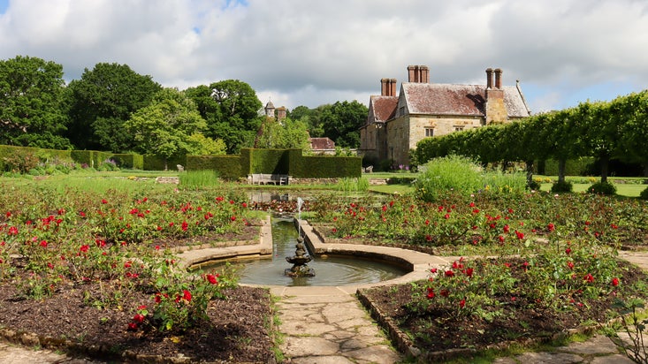 Looking over a bed of red and pink roses towards the Jacobean manor house.